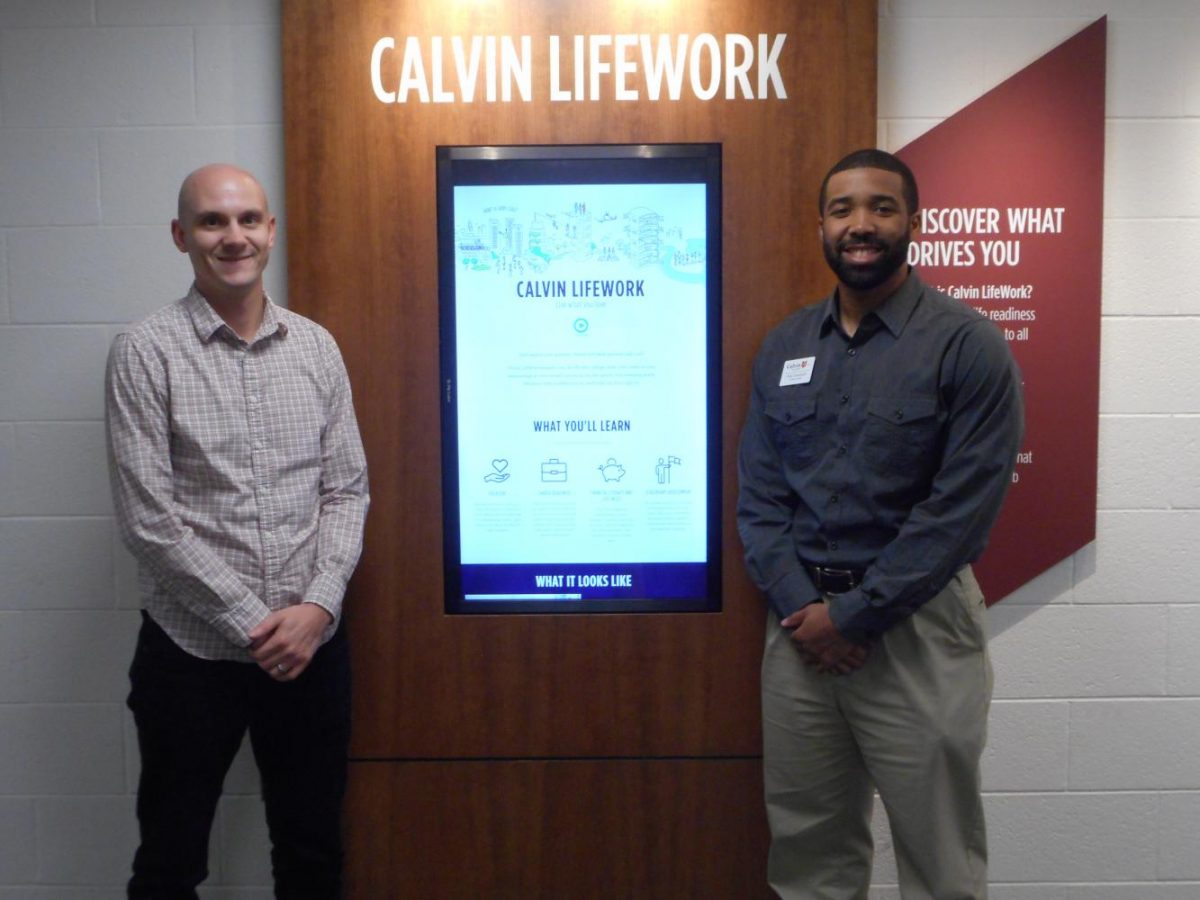 LifeWork+coaches+Brandon+Jacob+%28left%29+and+Wes+Tramwell+%28right%29+show+off+the+interactive+touch-screen+display+outside+of+Calvin%E2%80%99s+Career+Center.++Photo+by+Emily+Joy+Stroble.