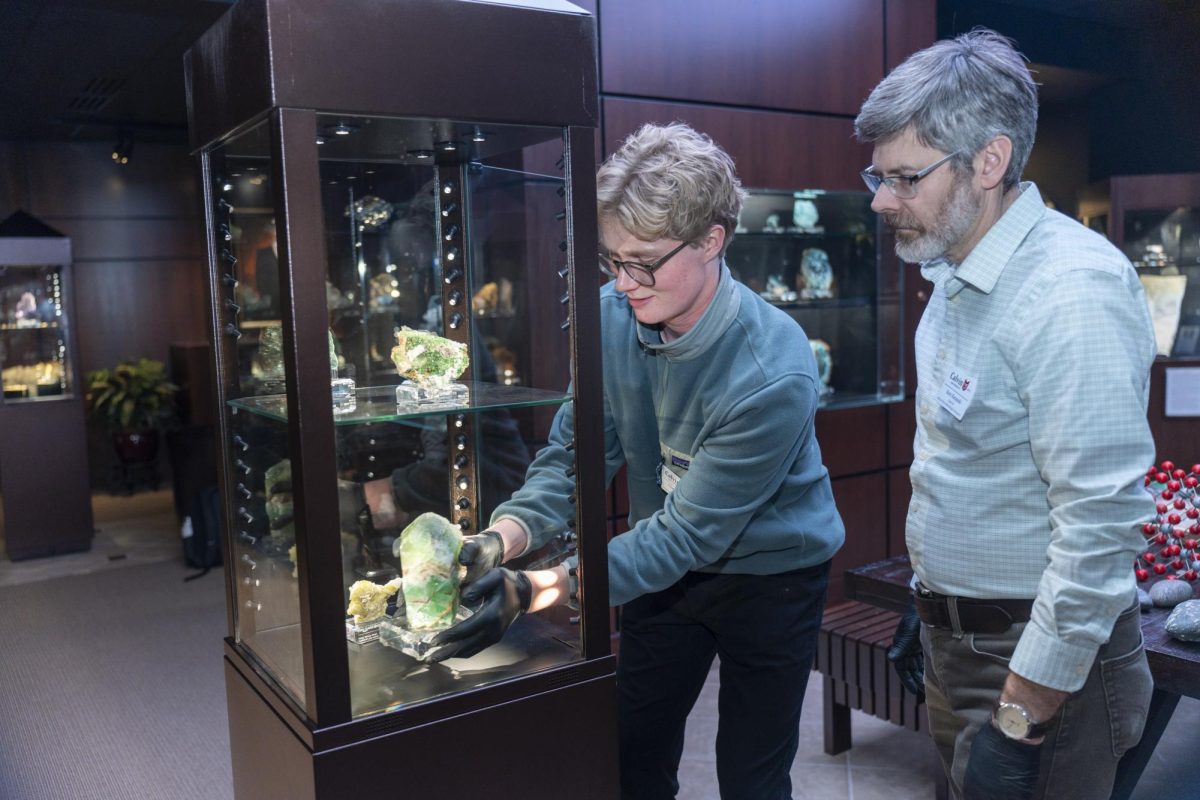 Current student curator Chafer Jolman is shown here working on a display in the Museum, alongside Museum director Kent Ratajeski.